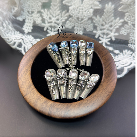 (Long-Length Coffin)These handmade press - on nails feature large oval blue crystals or intricate designs of smaller crystals and metal embellishments.