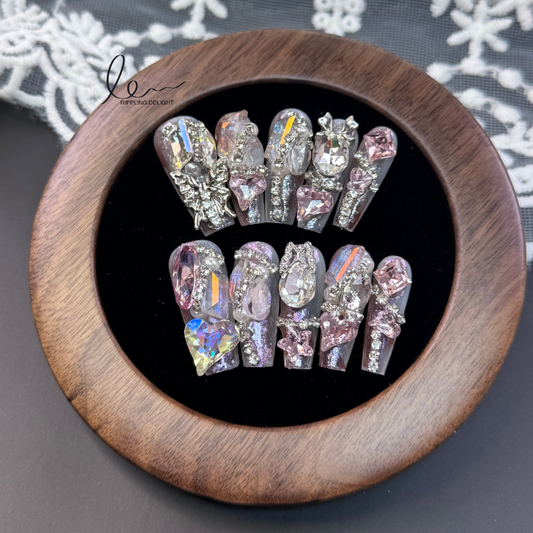 （Long-Length Coffin）The handmade nail tips are decorated with many shiny rhinestones and gemstones, mainly in pink, silver, and transparent.