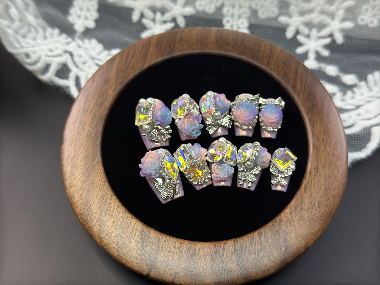 （Medium Coffin press-on nails）Handmade press-on nails with a pink base of fine glitter, colorful rhinestone inlays and floral accessories.